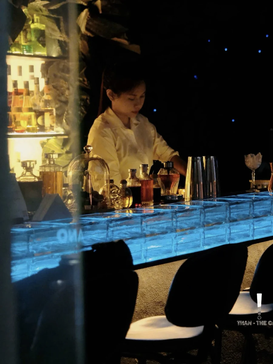 Bartender working behind the blue glass-block bar